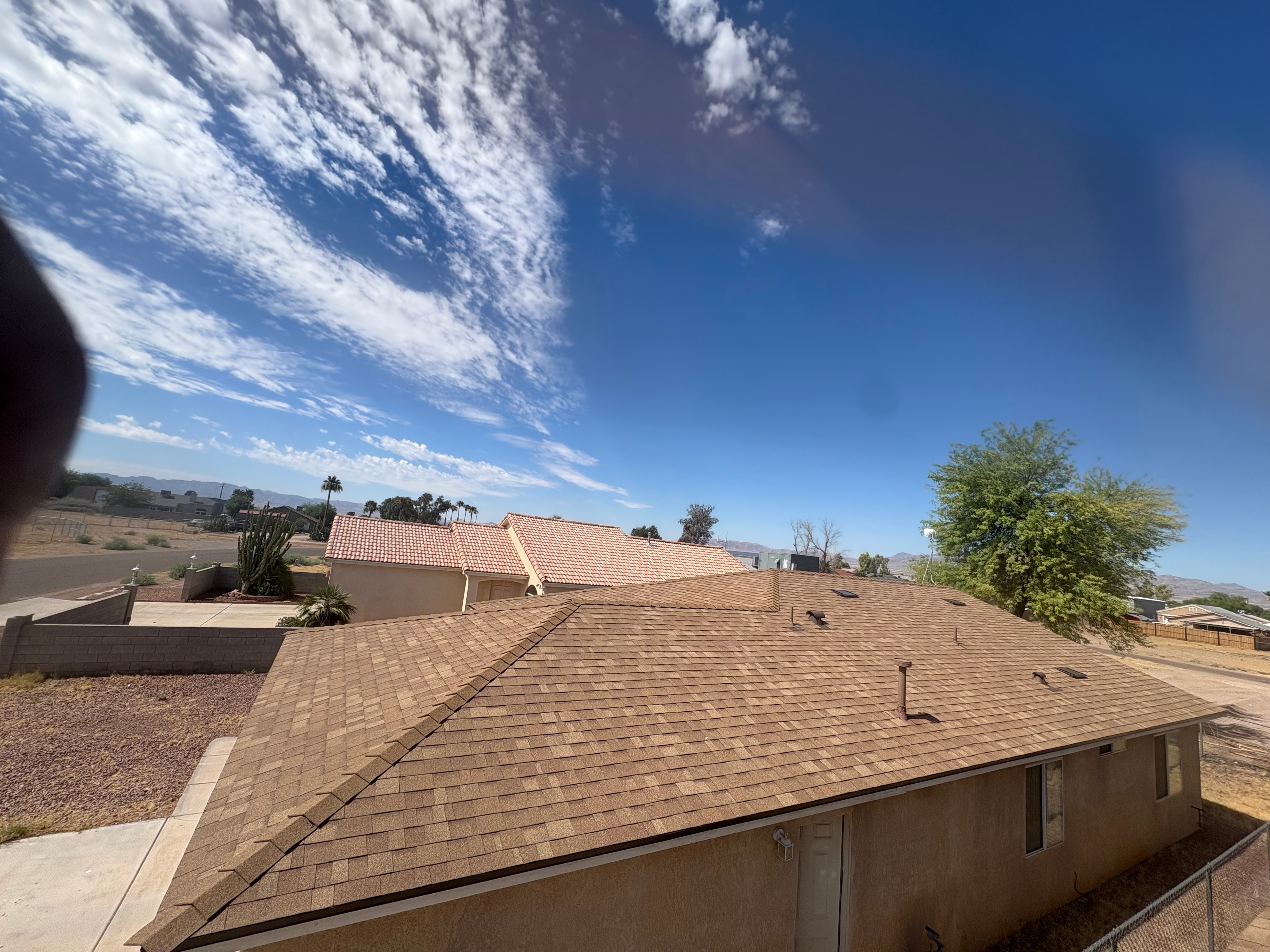 Residential shingle roof under blue sky