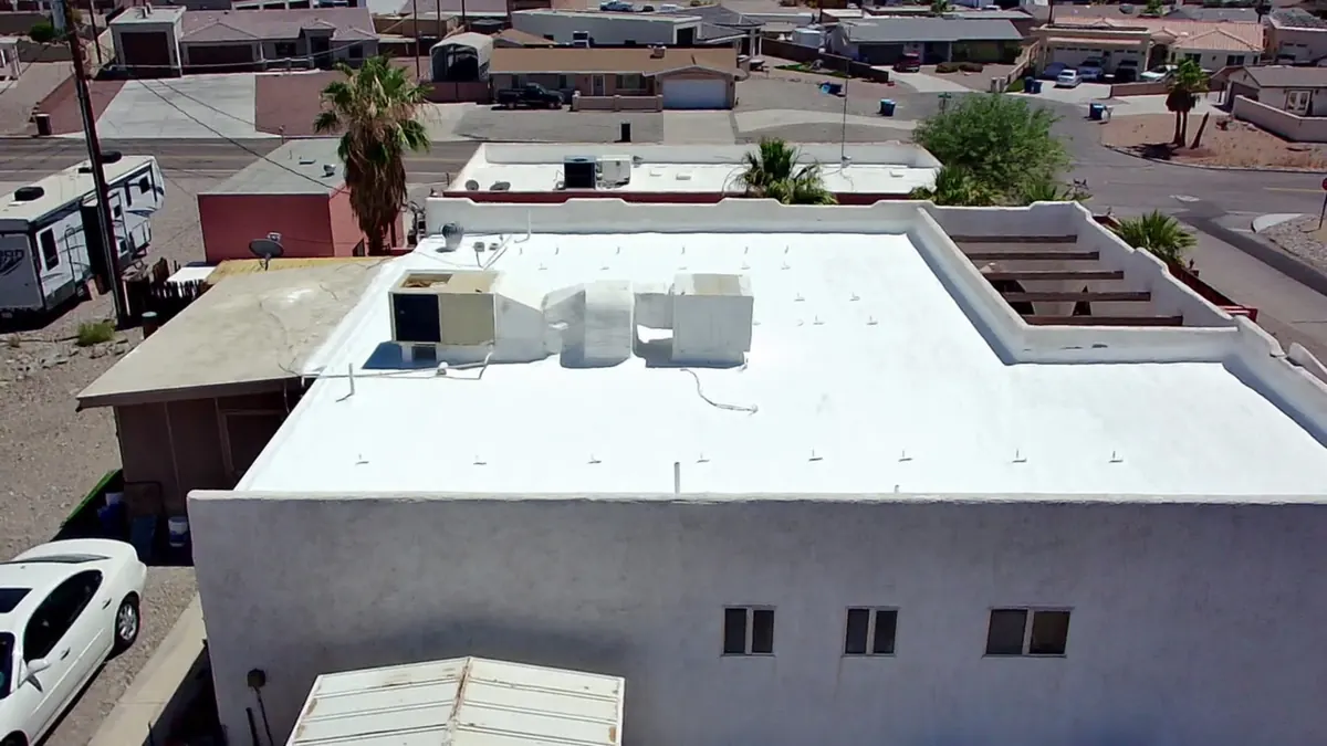 Aerial view of a freshly coated white flat roof with rooftop HVAC units on a Lake Havasu City home
